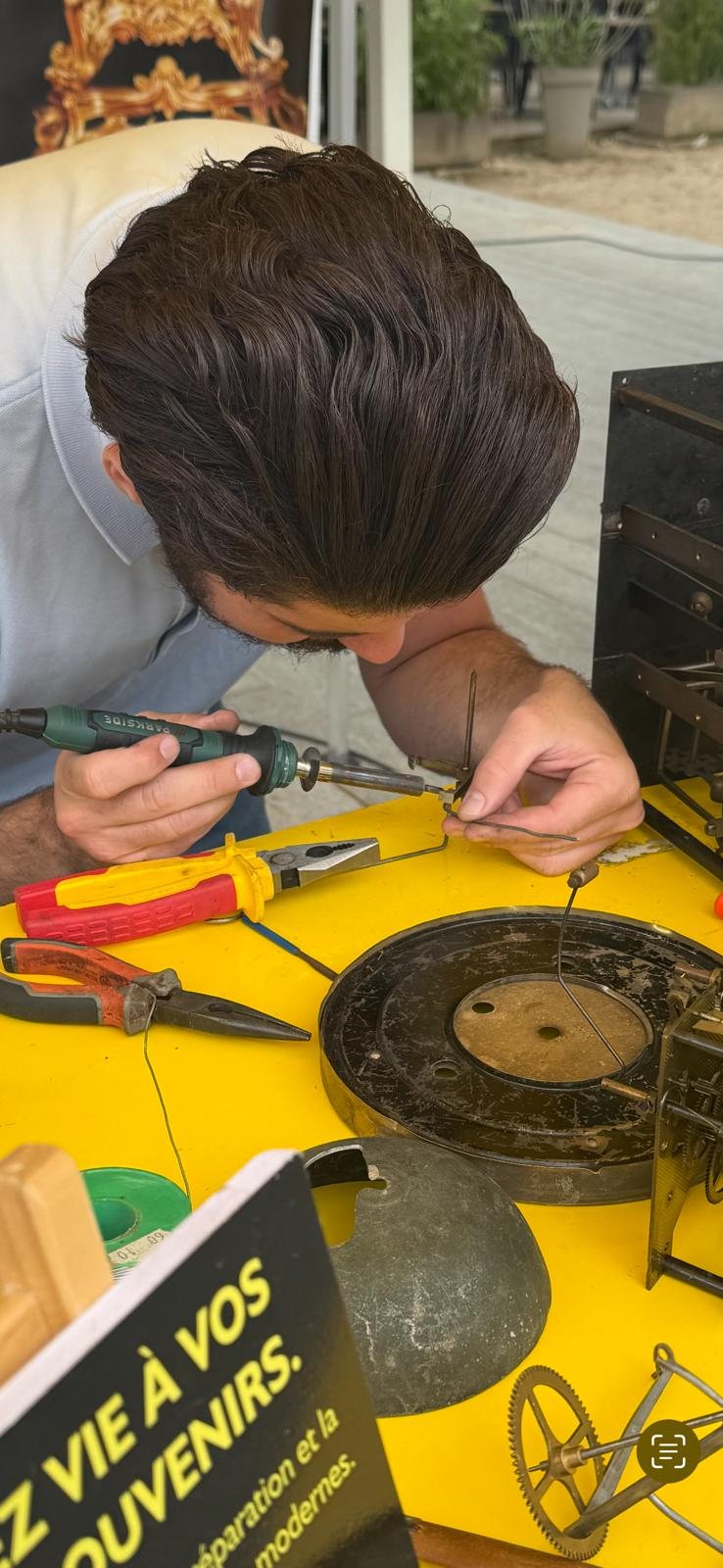 Horloger au travail sur un mouvement, loupe et outils sur l’établi