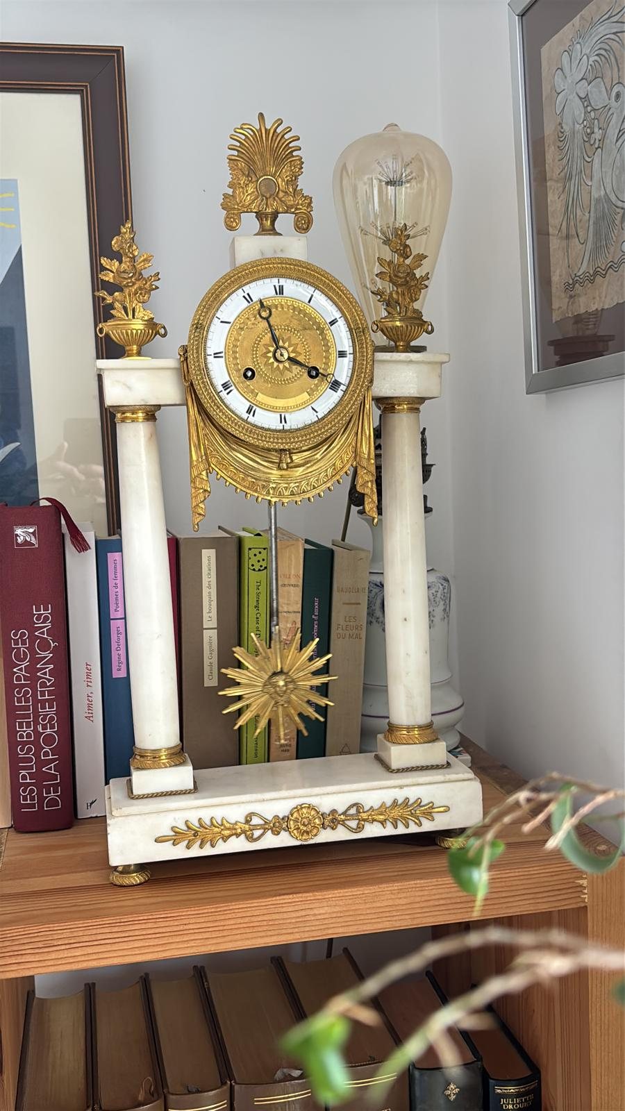 Pendule portique en marbre blanc et bronze doré, balancier soleil suspendu entre deux colonnes